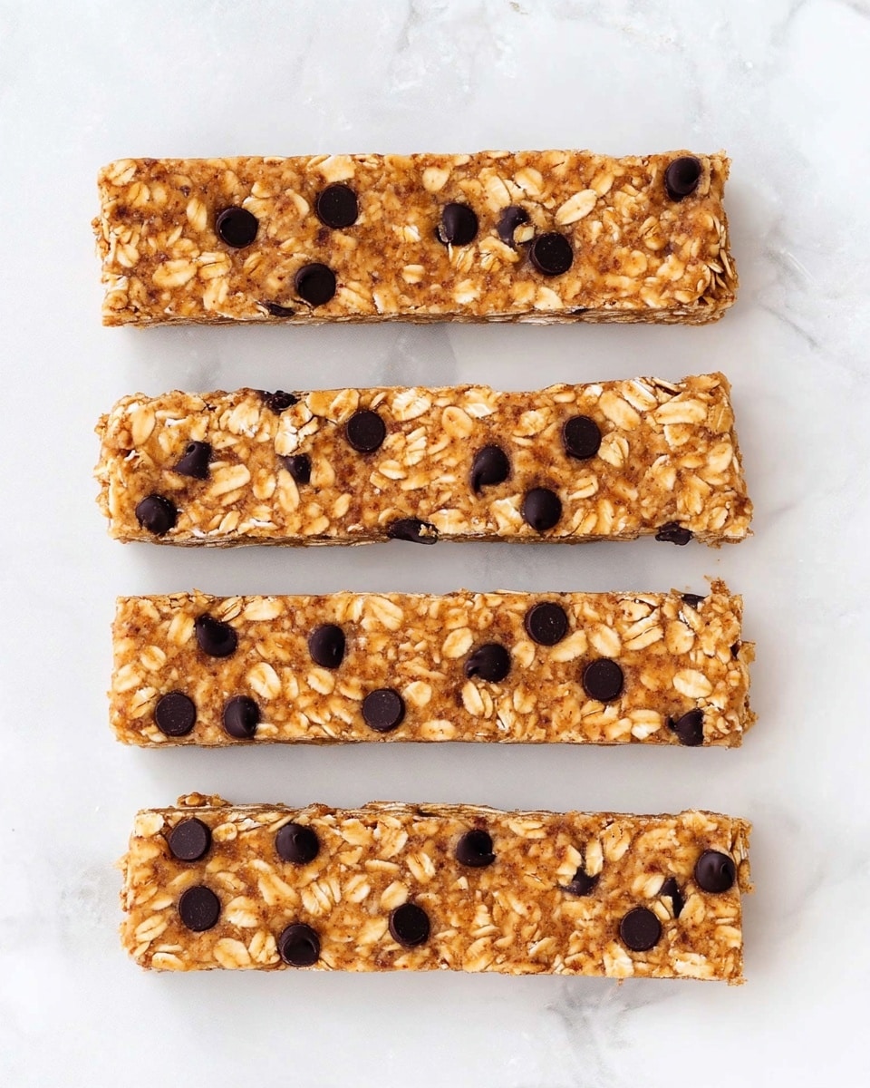 Five rectangular granola bars are arranged in a vertical line on a white marbled surface. Each bar has one thick layer with a light brown color, filled with visible oats and small dark chocolate chips scattered evenly throughout. The texture looks chewy and slightly rough due to the oats, while the chocolate chips add dark round spots across each bar. The bars have clean, straight edges and are placed with a small space between each other. Photo taken with an iphone --ar 4:5 --v 6.1