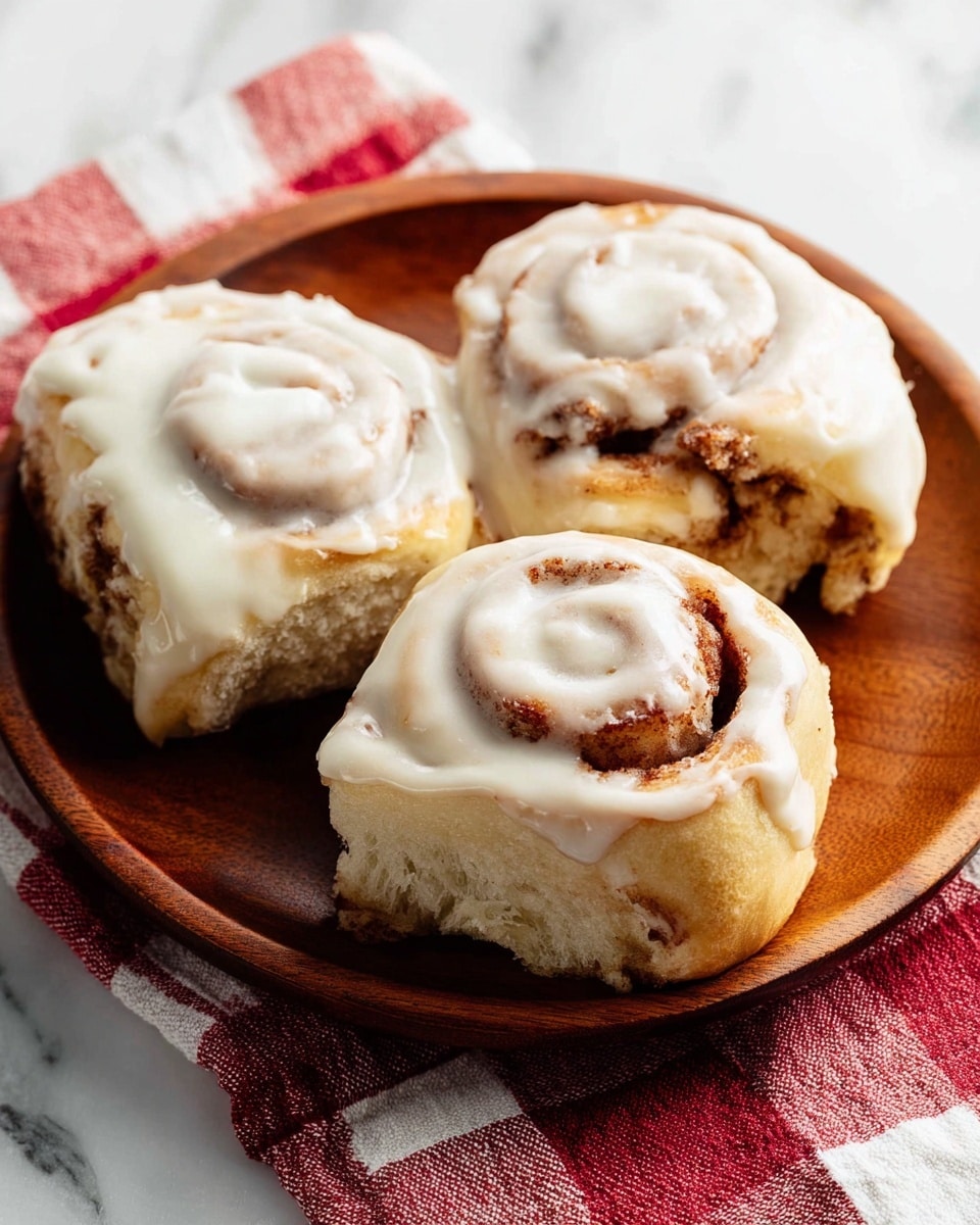 The image shows a black muffin tray with nine cinnamon rolls arranged in three rows of three. On the left side, the rolls are raw, pale with light beige dough and visible spirals of cinnamon brown filling, with a slightly rough and flour-dusted texture on top. On the right side, the rolls are baked, golden brown on the outer dough layers, with dark brown cinnamon spirals clearly visible and a glossy finish. The tray sits on a white marbled surface. photo taken with an iphone --ar 4:5 --v 7